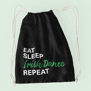 May include: Black drawstring bag with white text that reads "Eat Sleep Irish Dance Repeat". The word "Irish Dance" is in green.