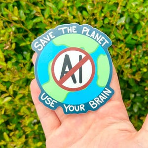Puede incluir: Una pegatina circular con un gráfico de un globo terráqueo azul y verde estilizado. En el centro, un círculo blanco contiene el texto negro AI con una línea diagonal roja. El texto del borde dice SAVE THE PLANET USE YOUR BRAIN en blanco.