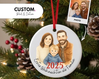 Könnte beinhalten: Weißer Keramik-Weihnachtsschmuck mit Familienporträt-Illustration, rotem Band und dem Jahr 2025. Der Schmuck trägt den Text "Erstes Weihnachten als Familie" und ein kleines Foto der Familie.