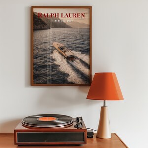 Luxury yacht speeding across the ocean at sunset with coastal mountains in the background, styled as elegant coastal lifestyle wall art.