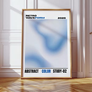 May include: A framed poster with a wooden frame. The poster features a blue and white abstract design with the text "RETRO WAVEFORM 2026" at the top and "ABSTRACT COLOR STUDY-02" at the bottom. The poster is leaning against a white wall.
