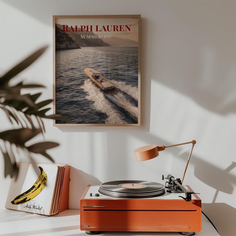 Luxury yacht speeding across the ocean at sunset with coastal mountains in the background, styled as elegant coastal lifestyle wall art.