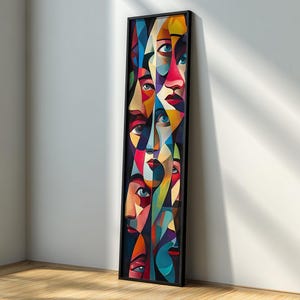 Könnte beinhalten: Ein gerahmtes abstraktes Kunstwerk mit einer Collage stilisierter Gesichter. Das Kunstwerk verwendet eine lebendige Farbpalette aus Rot, Blau, Gelb und Grün mit einem schwarzen Rahmen. Die Gesichter bestehen aus geometrischen Formen.