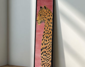 May include: A framed artwork featuring a leopard illustration. The leopard is depicted in profile with a long neck and spotted coat. The background is a solid pink color, and the frame is black.