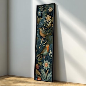May include: A tall, rectangular framed wall art piece featuring a dark blue background with a botanical pattern of light blue and white flowers, green foliage, red strawberries, and two small birds with orange and brown plumage perched within.