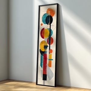 Könnte beinhalten: Abstrakter Kunstdruck in einem schwarzen Rahmen. Das Kunstwerk zeigt eine vertikale Komposition aus farbenfrohen geometrischen Formen, darunter Kreise und Rechtecke in Orange-, Türkis-, Rot-, Gelb- und Schwarztönen. Der Hintergrund ist ein neutrales Beige.