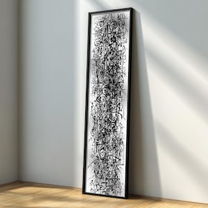 Puede incluir: Una obra de arte rectangular y alargada, enmarcada en negro, que presenta un complejo diseño abstracto en tinta negra sobre fondo blanco. La obra se apoya en una pared blanca sobre un suelo de madera, creando un ambiente moderno.