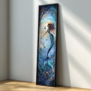 May include: A framed vertical art print featuring a mermaid in a swirling underwater scene. The mermaid has flowing auburn hair and a blue tail. The artwork is predominantly blue with accents of orange and green, creating a vibrant aquatic theme.