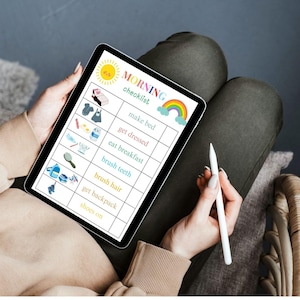 May include: A tablet displaying a colorful "MORNING checklist" with illustrations for tasks like making the bed and brushing teeth. The tablet is held by a person, along with a white stylus.