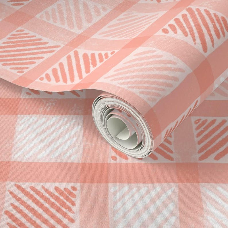 Pu&ograve; includere: Un rotolo di carta da parati con un motivo a quadri vichy pesca e bianco. Il design incorpora forme astratte e strutturate all'interno dei quadrati. Il rotolo &egrave; parzialmente srotolato, mostrando il motivo. Ideale per la decorazione.