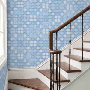 May include: A staircase with wooden steps and a dark brown handrail. The wall is covered in blue and white plaid wallpaper. The stairs have white risers and the wall has a white baseboard.