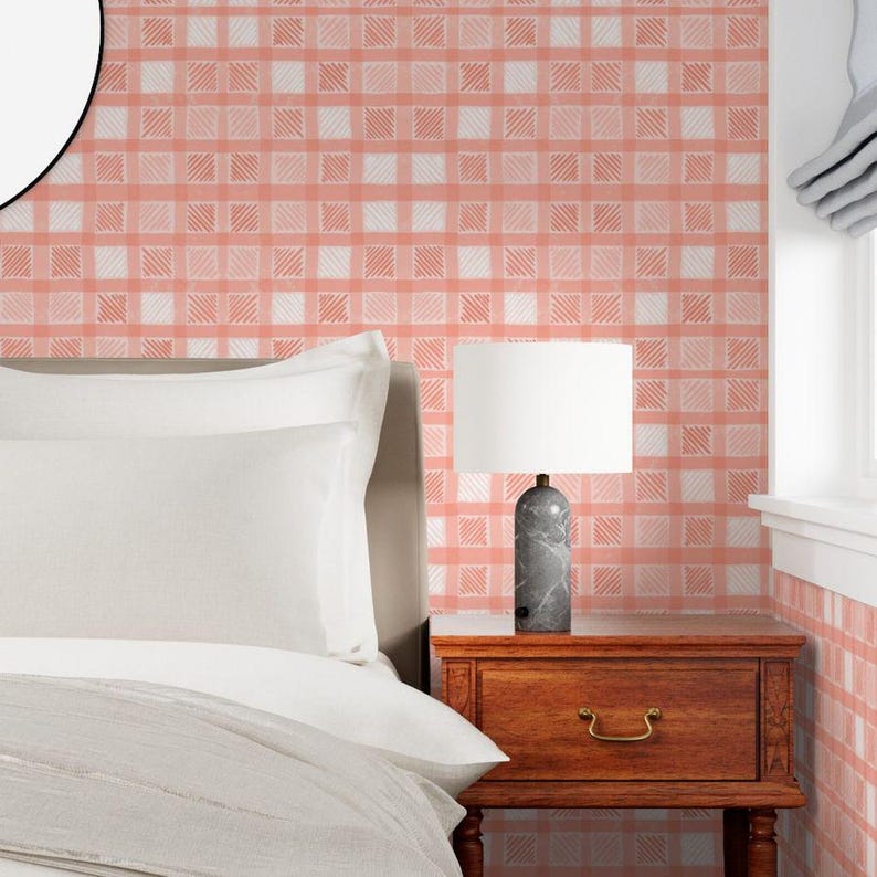 Pu&ograve; includere: Una scena di camera da letto con un letto, un comodino e una lampada. Il letto ha biancheria da letto bianca. Il comodino &egrave; in legno. La lampada ha un paralume bianco e una base in marmo grigio. La parete &egrave; rivestita da carta da parati a quadri rosa e bianchi.