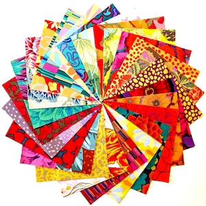 May include: A circular arrangement of colorful fabric squares. The squares display a variety of floral and abstract patterns in shades of red, yellow, green, blue, and purple. The fabric appears to be cotton or a similar material, suitable for quilting or crafting projects.