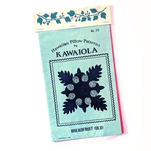 May include: A vintage Hawaiian pillow pattern booklet by KAWAIOLA. The cover is light blue with a dark blue floral design and the words "Hawaiian Pillow Patterns" and "Breadfruit (Ulu)". The booklet has a decorative border and a floral design at the top.