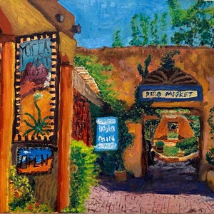 May include: An oil painting depicts a vibrant outdoor market scene. The artwork features a building with a sign that reads "Yocla Art Gallery" and "Open". A sign for "Patio Market" is visible through an archway, with lush greenery and a blue sky.