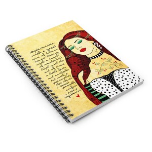 May include: A spiral bound notebook with a yellowed background featuring a colorful illustration of a woman with red hair and a quote about being optimistic and a Sagittarius. The quote reads "optimistic with a great sense of humor honest loving with a touch of wanderlust loyal until the end of time a little fiery and complex but with a personality that shines must proudly confess I am a Sagittarius."