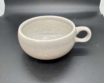 Russel Wright American Modern flat cup in the Granite Gray glaze, produced by the Steubenville Pottery Company.