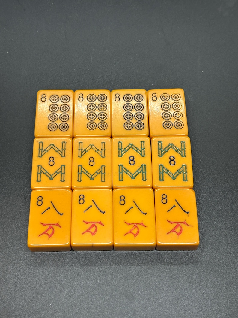 K&ouml;nnte beinhalten: Zw&ouml;lf orangefarbene Mahjong-Steine, angeordnet in drei Reihen. Die Steine zeigen Symbole wie Kreise, Bambus und chinesische Schriftzeichen. Jeder Stein ist mit der Zahl "8" markiert.