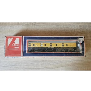 Può includere: Un vagone ferroviario modello nella sua scatola originale. Il vagone è giallo e nero con la scritta "Great Western" stampata sul lato. La scatola è rossa e blu con il logo "Lima models".
