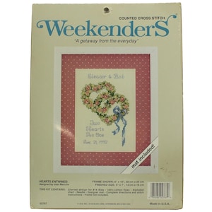 May include: Cross stitch pattern kit for a wedding or anniversary gift. The pattern features two intertwined hearts with a ribbon and the text "Two Hearts As One" with the names "Eleanor & Bob" and the date "June 21, 1992". The finished size is 5 inches by 7 inches.