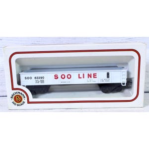 May include: A white HO scale model train car with the words "SOO LINE" in red. The model train car is in a white and red box with the Bachmann logo.
