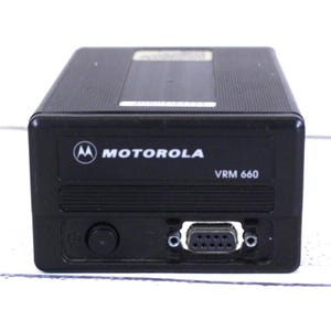 May include: Black Motorola VRM 660 radio transceiver. The device has the Motorola logo and the text "VRM 660" printed on the front. It features a round button, a serial port, and a rectangular design.