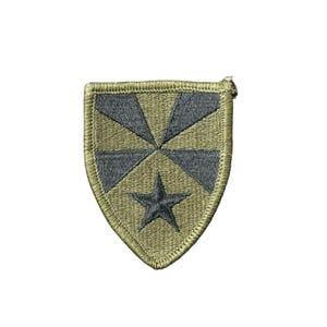 May include: A green and black embroidered patch with a star in the center and a design of four triangles around the star.