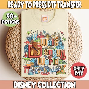May include: A light yellow t-shirt with a colorful graphic design featuring the text "Walt Disney World" and various Disney characters and landmarks. The design includes Chewbacca, a castle, a spaceship, and a rollercoaster. The text "Orange DTF" is visible in the upper left corner of the shirt.
