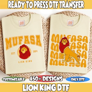 May include: Two cream-colored t-shirts with "MUFASA" and a lion graphic. One shirt has "MUFASA" in large orange letters with a lion graphic and "EST. 1994 LION KING". The other shirt has "MUFASA" repeated with a lion graphic. Text reads "READY TO PRESS DTF TRANSFER" and "450+ DESIGNS".