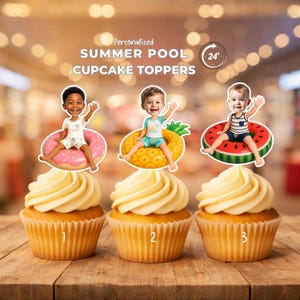 Peut inclure: Trois cupcakes surmontés de découpes en papier personnalisées représentant des enfants assis dans des bouées de piscine gonflables en forme de beignet rose, d'ananas jaune et de tranche de pastèque rouge. Le texte indique SUMMER POOL CUPCAKE TOPPERS.