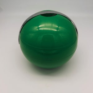 May include: A green plastic ice bucket with a silver metal handle. The bucket is round and has a smooth surface.