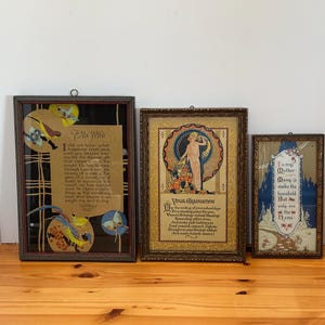 Könnte beinhalten: Drei gerahmte Vintage-Kunstwerke. Das größte zeigt Text und dekorative Vogel- und Blumenelemente. Das mittlere Stück hat eine Frauenillustration mit Text. Das kleinste hat eine blaue und goldene Landschaft mit Text.