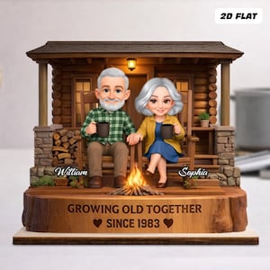May include: A decorative figurine of an elderly couple sitting on a porch, holding mugs. The figurine is set in front of a miniature log cabin with a sign that reads "Growing Old Together Since 1983".