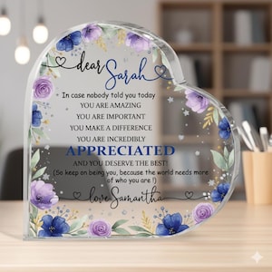 May include: Heart-shaped clear acrylic plaque with floral accents in blue and purple. The plaque has the words "dear Sarah" and a message of appreciation, signed "love Samantha". A decorative gift item.