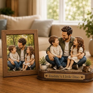 May include: A framed photo and a decorative figurine of a father with two children. The photo is in a brown wooden frame. The figurine has a bronze plaque that reads "Daddy's Little Duo". The father and children are wearing casual clothing.
