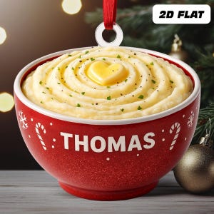 May include: A red Christmas ornament shaped like a bowl of mashed potatoes, topped with a heart-shaped pat of butter. The bowl has the name "THOMAS" in white, with candy cane and snowflake designs.