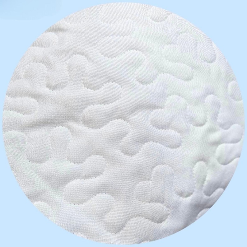 Puede incluir: Una pieza de tela circular blanca que presenta un patr&oacute;n ondulado continuo, elevado y cosido en toda la superficie. La textura est&aacute; creada por l&iacute;neas acolchadas densas y entrelazadas que forman formas org&aacute;nicas y fluidas en el material.