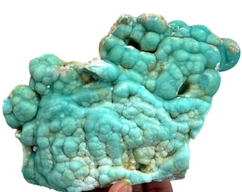 May include: A large, blue-green, botryoidal, mineral specimen with a rough, textured surface.