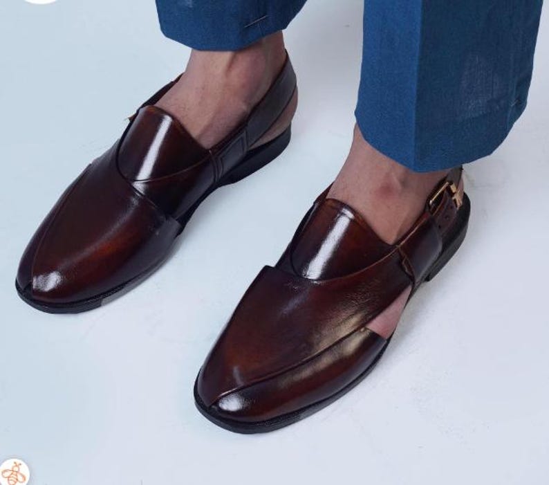 May include: Dark brown leather sandals with a polished finish. The sandals feature a closed-toe design, a strap across the top, and a buckle fastening. The shoes are a deep brown colour.