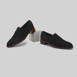 Handmade black suede penny loafers for men featuring a classic slip on silhouette, premium suede leather upper, leather sole, elegant formal design, luxury dress footwear ideal for weddings, business attire, office wear, and special occasions.