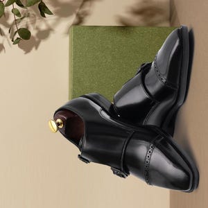 Handmade black double monk strap shoes for men featuring premium smooth leather, elegant cap toe detailing, dual buckle closure, and luxury formal styling, perfect for weddings, groom attire, business meetings, office wear, black tie events, and sophisticated professional fashion.
