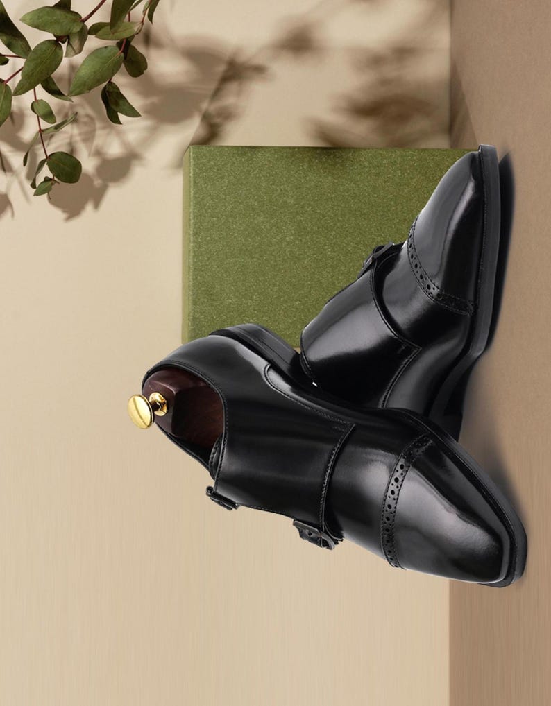 Handmade black double monk strap shoes for men featuring premium smooth leather, elegant cap toe detailing, dual buckle closure, and luxury formal styling, perfect for weddings, groom attire, business meetings, office wear, black tie events, and sophisticated professional fashion.