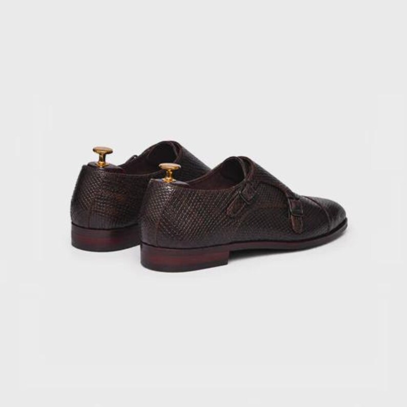 Handmade brown double monk strap shoes for men featuring snake embossed leather texture, cap toe design, dual buckle closure, leather lining and sole, luxury formal footwear ideal for weddings, business attire, office wear, and special occasions.
