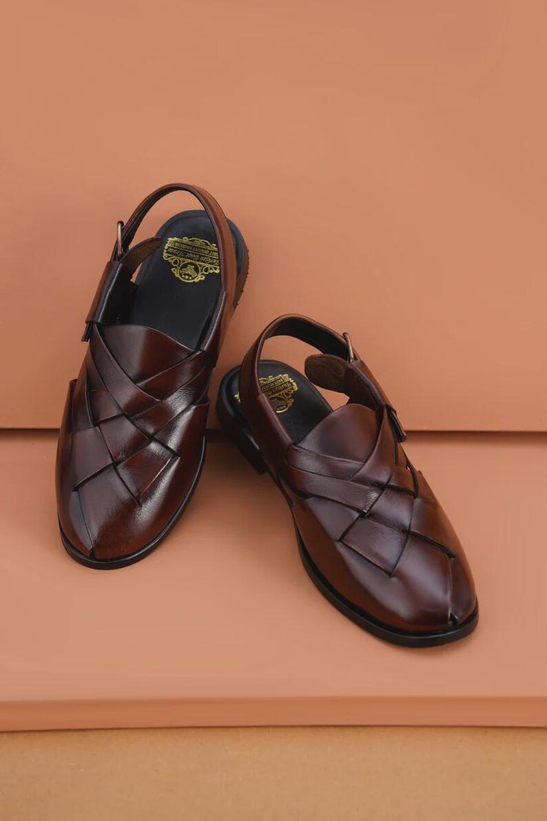 Handmade brown leather Peshawari sandals with woven closed-toe design and adjustable buckle for men's traditional and formal wear.