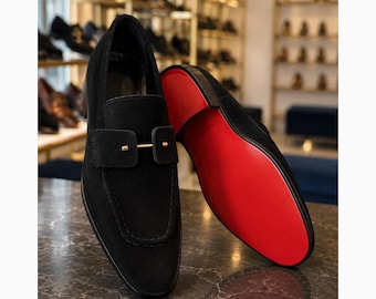 Zwarte suède loafers, handgemaakte herenschoenen met rode leren zool.