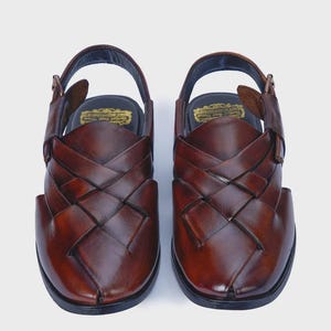Handmade brown leather Peshawari sandals with woven closed-toe design and adjustable buckle for men's traditional and formal wear.