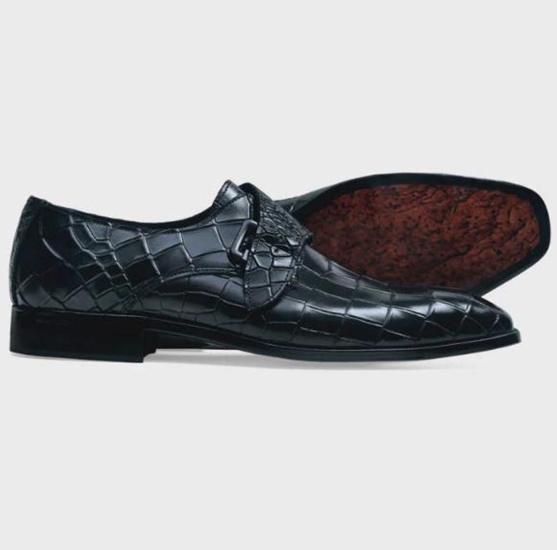 Handmade black crocodile embossed leather monk strap loafers for men featuring a textured buckle strap, premium leather lining, elegant slip-on design, and luxury craftsmanship for weddings, office wear, business meetings, and formal occasions.