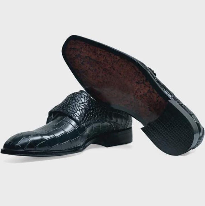 Handmade black crocodile embossed leather monk strap loafers for men featuring a textured buckle strap, premium leather lining, elegant slip-on design, and luxury craftsmanship for weddings, office wear, business meetings, and formal occasions.