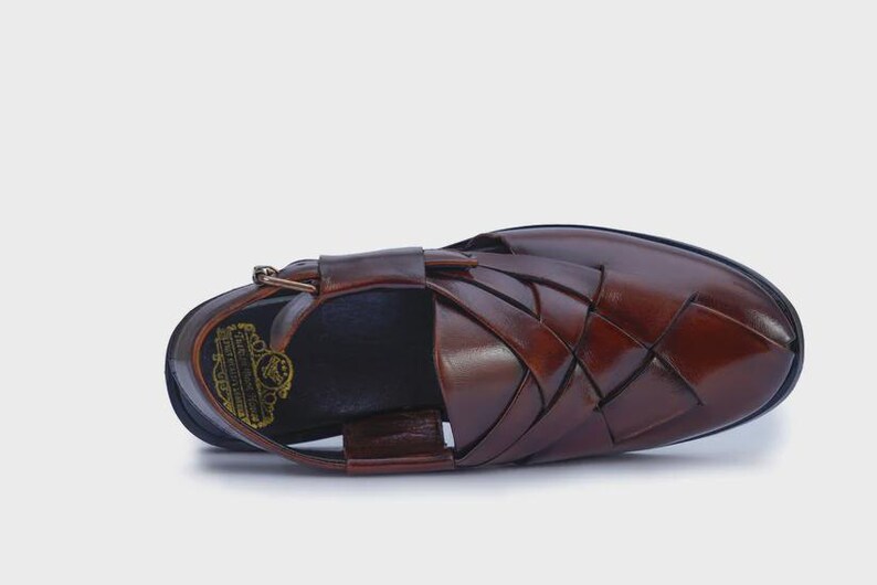 Handmade brown leather Peshawari sandals with woven closed-toe design and adjustable buckle for men's traditional and formal wear.