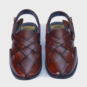 Handmade brown leather Peshawari sandals with woven closed-toe design and adjustable buckle for men's traditional and formal wear.